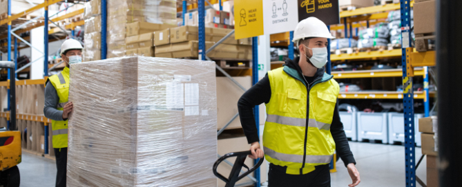 supply chain working in a warehouse with face masks covid safe