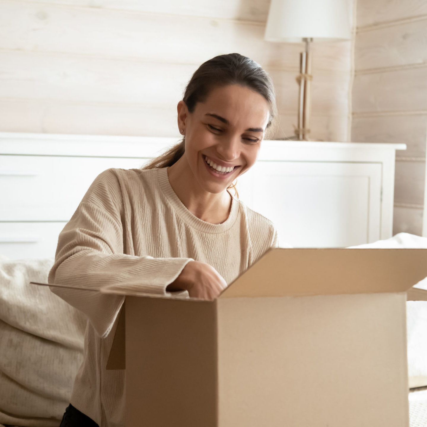 woman at home opening a parcel