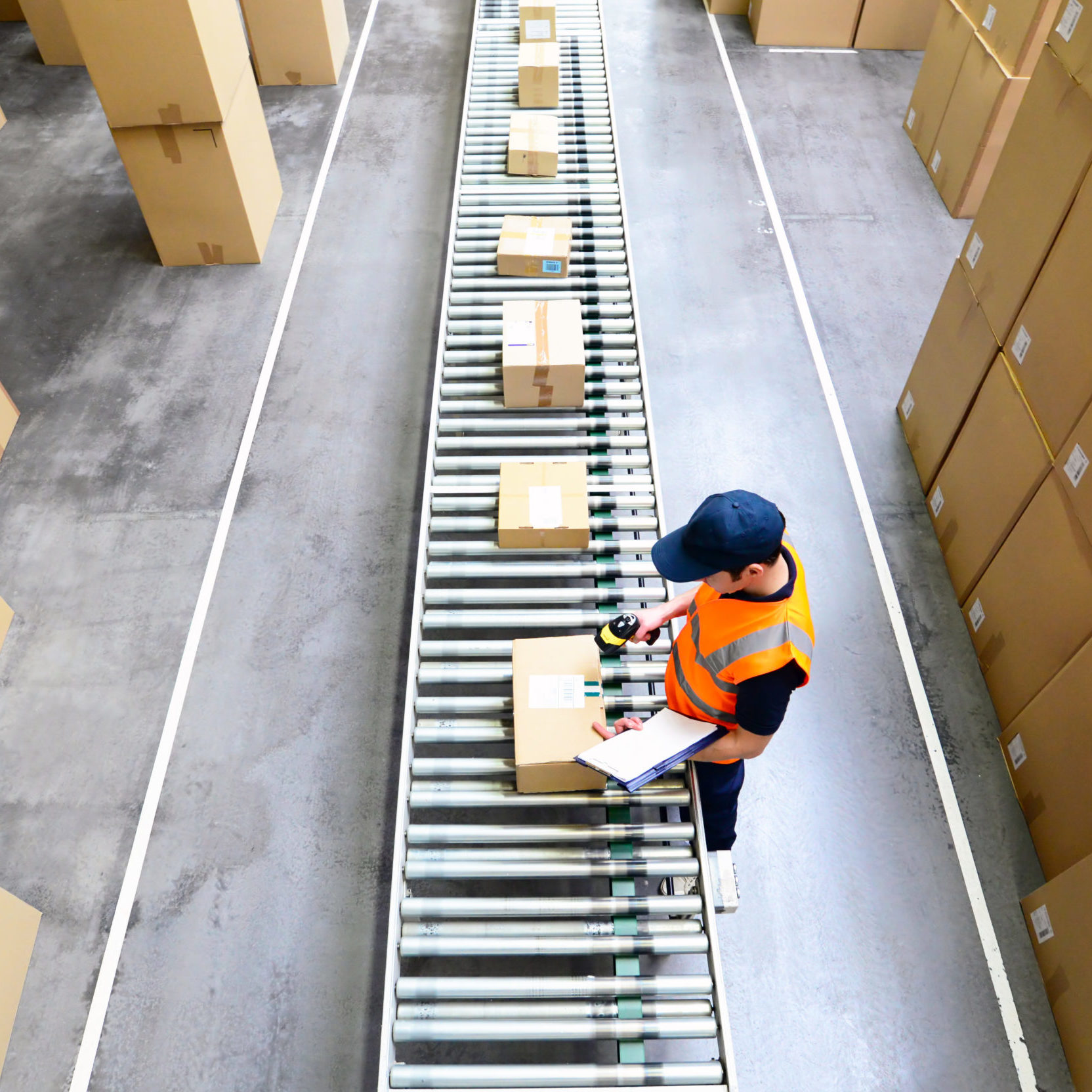 warehouse worker scanning parcels on belt