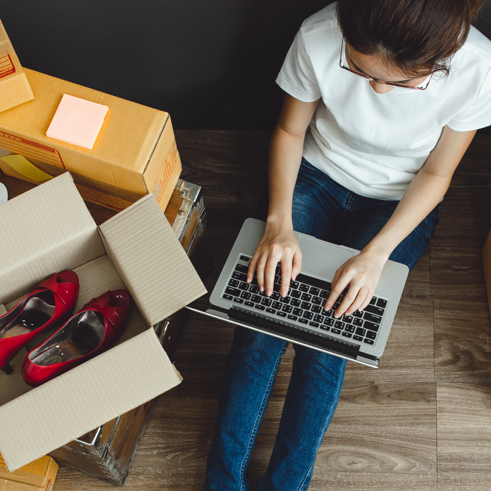 woman online shopping at home surrounded by parcels