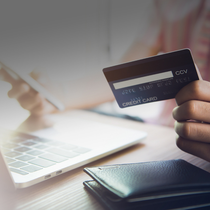online shopping - man holding credit card whilst shopping online